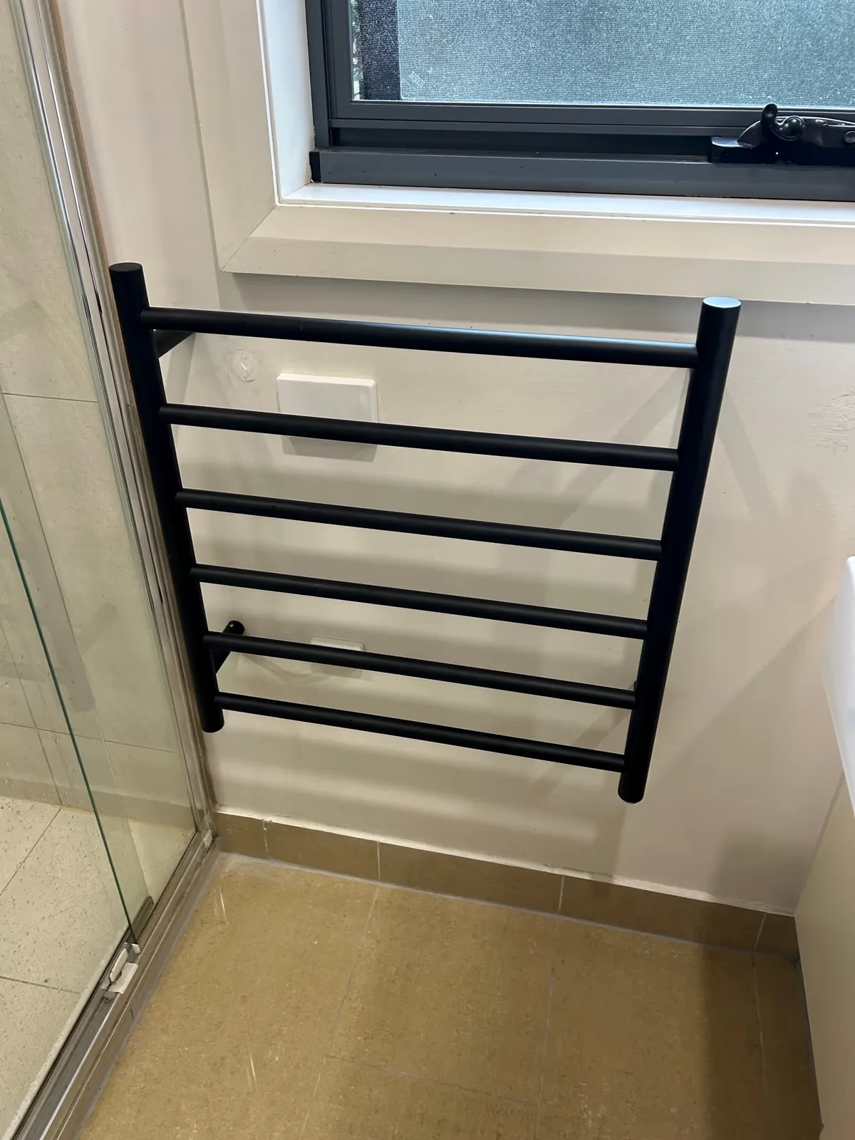 Heated towel rail fitted in a bathroom by Espire Electrical