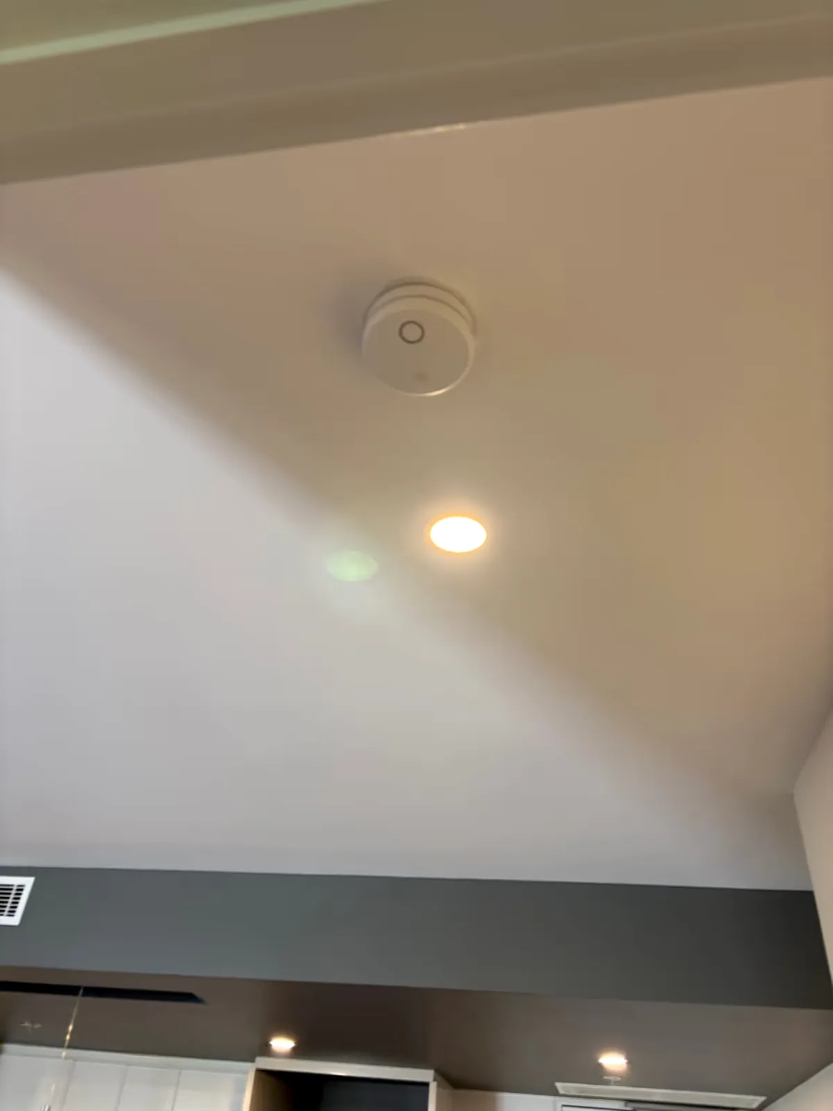 Smoke alarm and recessed light fitted to a ceiling by Espire Electrical
