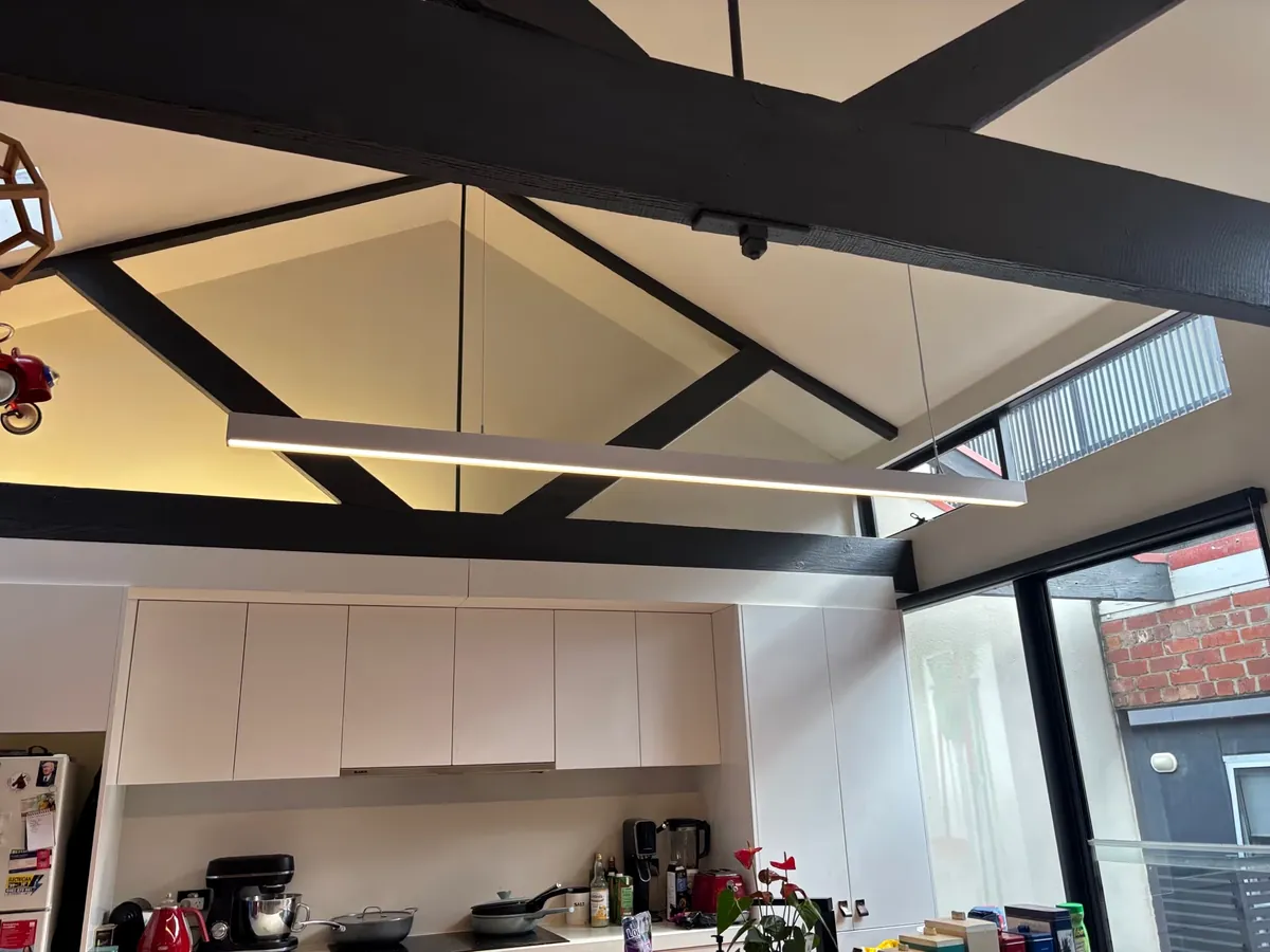 Completed kitchen lighting beneath exposed ceiling beams by Espire Electrical