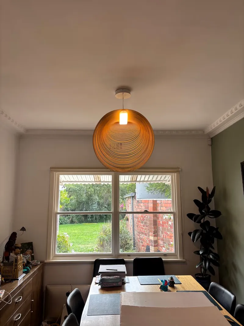 Warm pendant light above a dining table installed by Espire Electrical